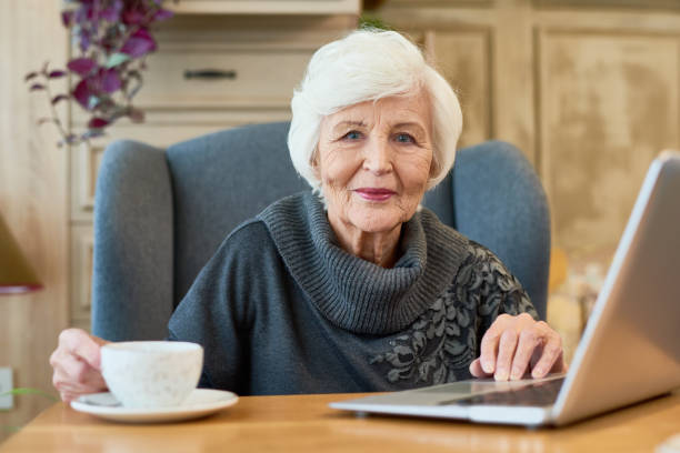 Smiling Senior Woman Using Laptop