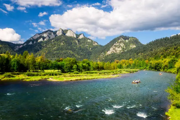 The river tour across Dunajec gorge. Raftmens and turists sitting on special rafts and admiring beauty of Pieniaski National Park in unusual and fascinating way. The river tour lasts from 2 to 3 hours