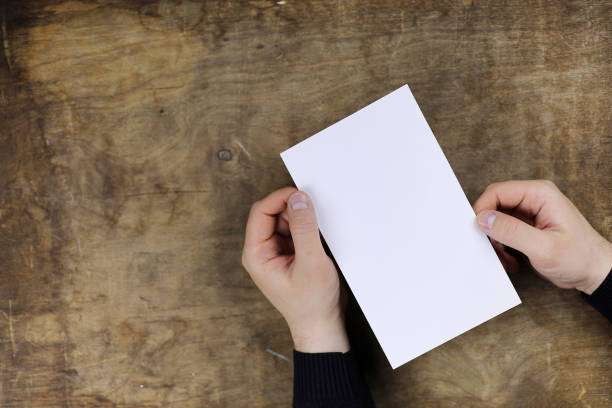 istock male hands holding a white blank sheet of paper 891399084