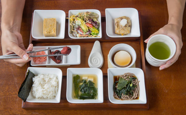 istock Young woman eats steam rice. Typical japanese breakfast 891404360