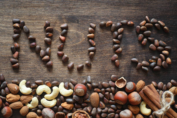 istock Different nuts on a wooden table. Cedar, cashew, hazelnut, walnu 891407674