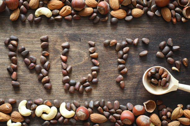 istock Different nuts on a wooden table. Cedar, cashew, hazelnut, walnu 891408120