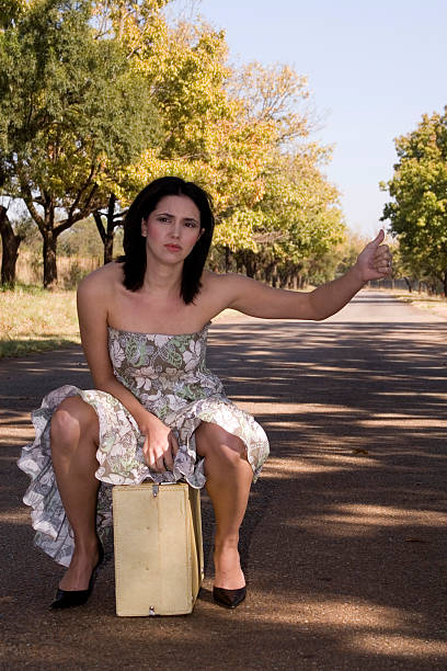 Sad brunette sitting on suitcase stock photo