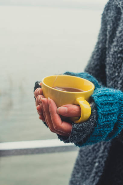 istock Yellow cup of tea at the female hands 891415710