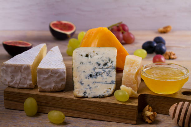 istock Cheese selection on wooden rustic background. Cheese platter with different cheeses 891419236