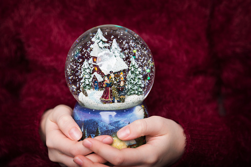 Christmas snowglobe in girl's hands