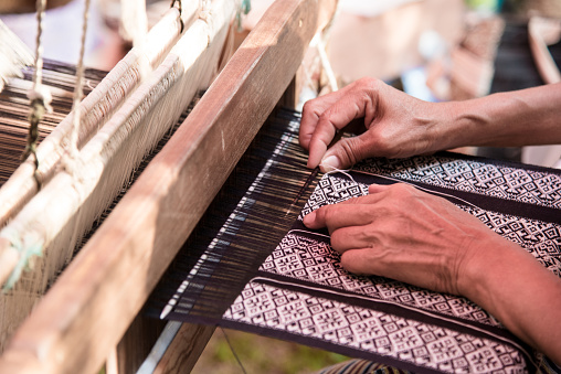 Close up Weavers are weaving with a loom and threading.