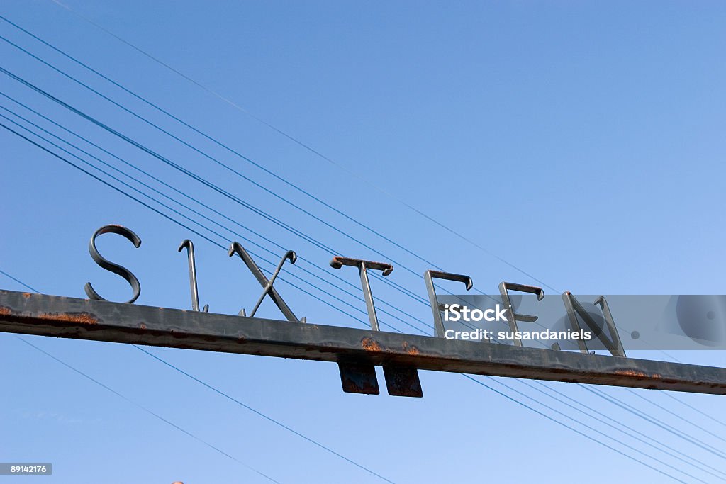 metal sign above a gate with number sixteen rusted metal sign, low angle, power lines in the background Color Image Stock Photo