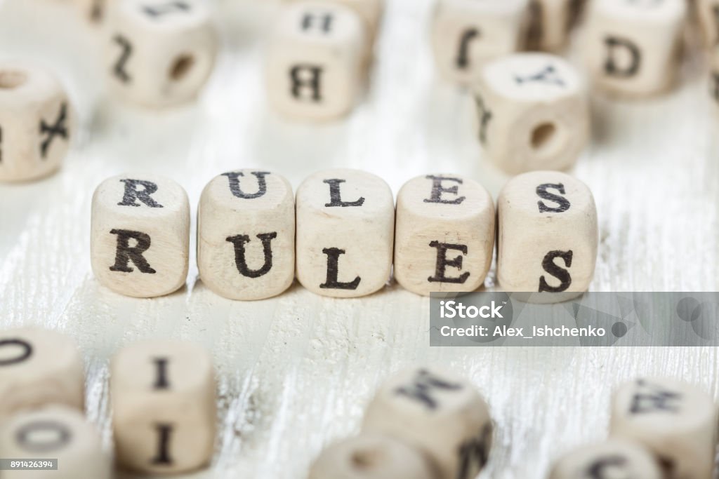 Rules word written on wood block. Word RULES formed by wood alphabet blocks. On old wooden table. Rules Stock Photo