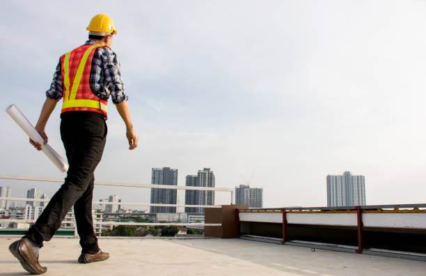 Professional Foreman wearing safety helmet hold blueprint while walking on the building deck