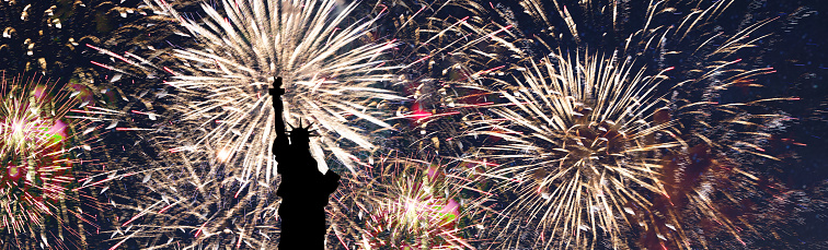 Fireworks light up the sky with dazzling display, and the statue of liberty