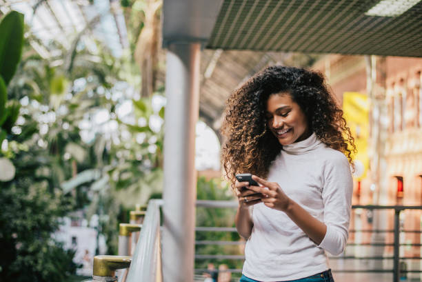 istock Beautiful curly long brunette hair woman using smart phone 891432800