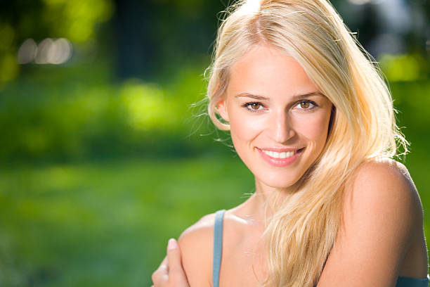 istock Smiling blonde woman against a blurred green background 89143412