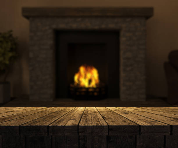 istock 3D wooden table looking out to a defocussed fireplace with roaring fire 891434388