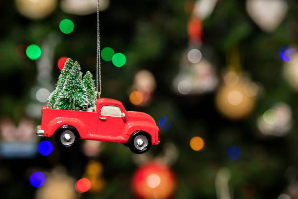 Red pickup car with Christmas tree hanging on Christmas tree stock photo