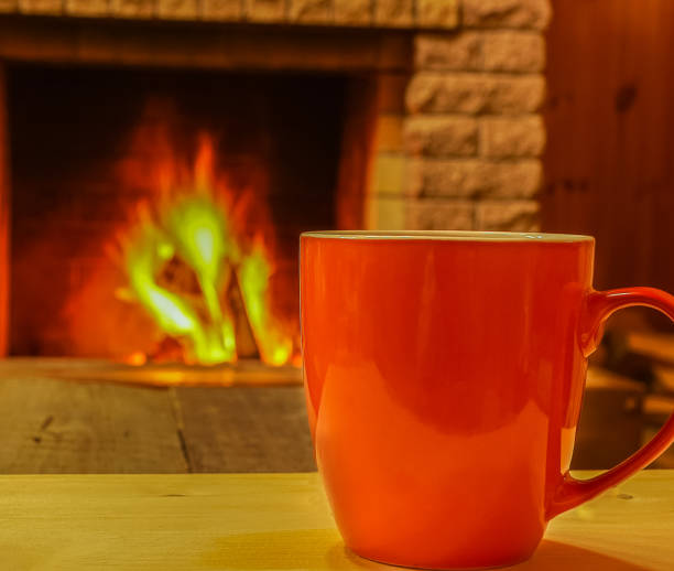 istock Mug of  tea or coffee near  cozy fireplace. 891437536