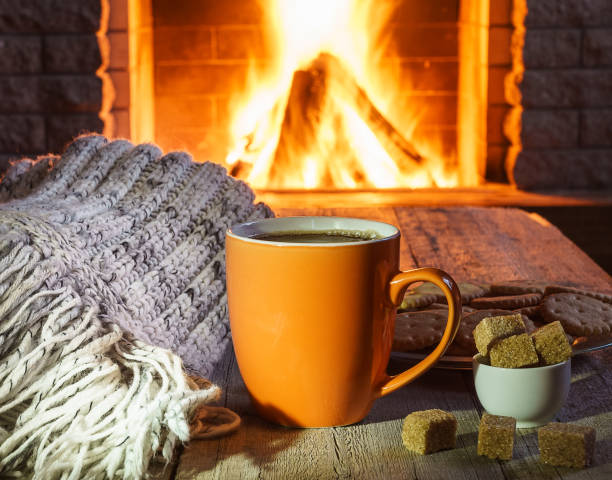 istock Cup of tea and sugar,  woolen things near  cozy fireplace. 891437600