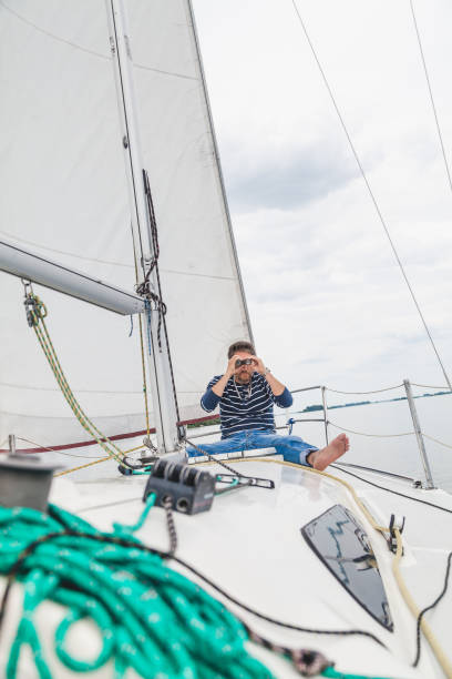 istock man sits on sailing yacht and looks through binoculars 891444934