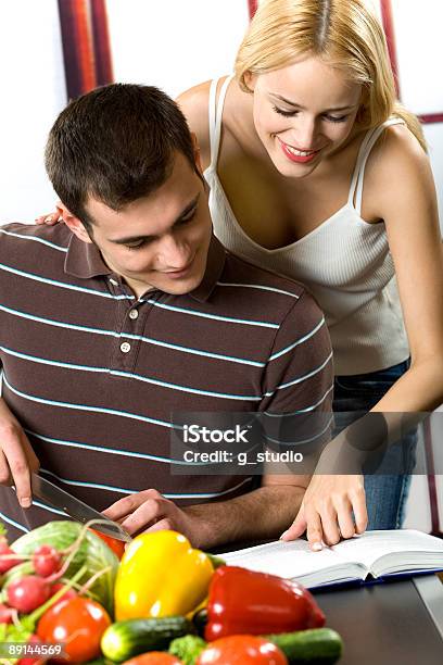 Jovem Atraente Casal Feliz Sorridente Cozinhar Na Cozinha - Fotografias de stock e mais imagens de Adulto