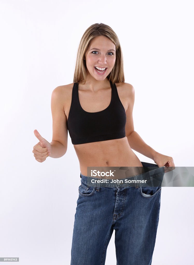 Successful diet Happy young woman showing how much weight she lost 20-29 Years Stock Photo