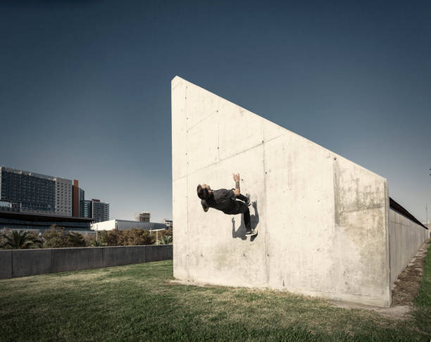 istock Man running up wall while practicing parkour in the city 891453132