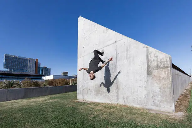 Man jumping and doing backflips while practicing parkour in the city