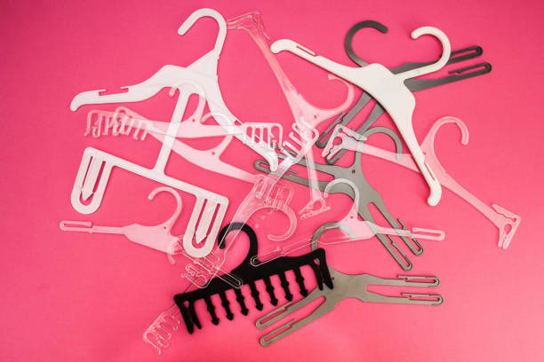 istock A scattered set of clothes hangers on a pink background. 891455542