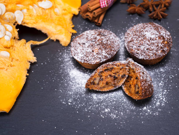 istock Pumpkin cupcakes on a black background, top view 891455916