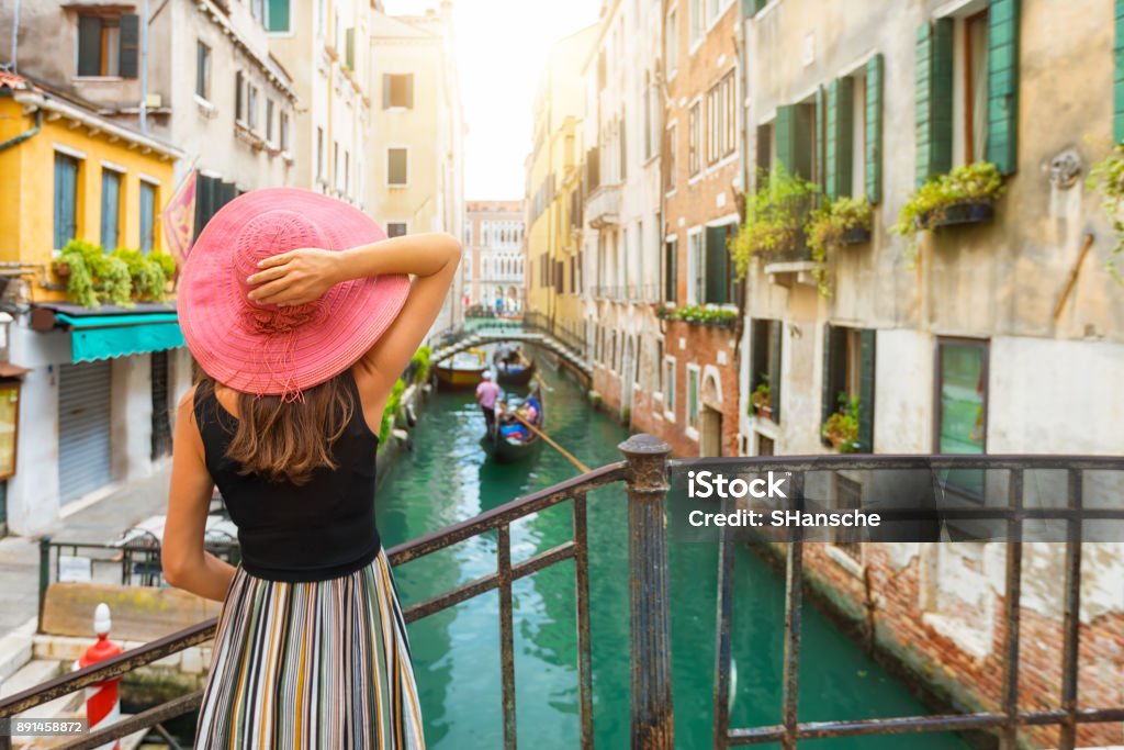 Donna elegante gode della vista su un canale a Venezia - Foto stock royalty-free di Venezia