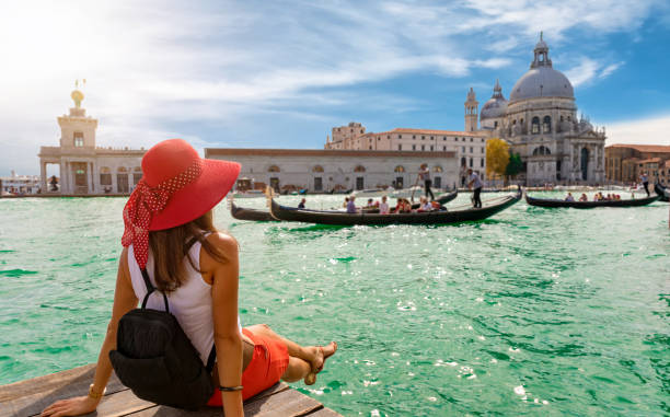 weibliche touristen auf der suche der basilika di santa maria della salute und canale grande in venedig, italien - tourismus stock-fotos und bilder