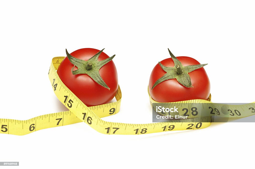 Tomates e fita métrica ilustrando o conceito de dieta - Foto de stock de Alimentação Não-saudável royalty-free