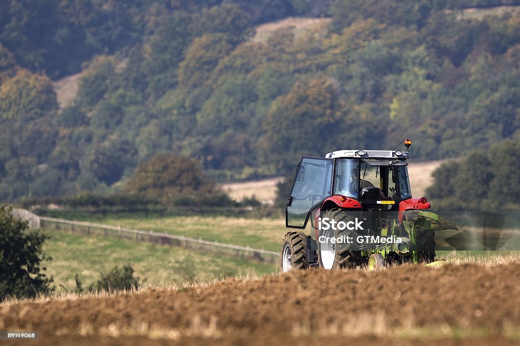 Tractor ploughing un campo - Foto de stock de Agricultura libre de derechos