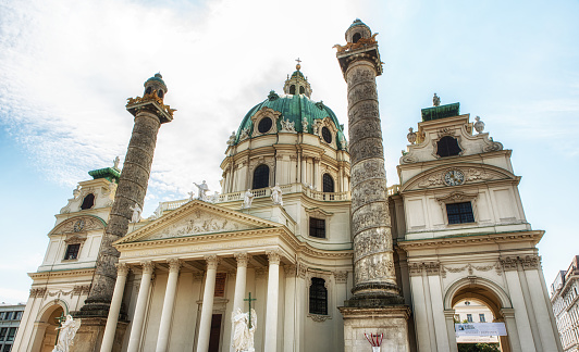 Vienna, Austria - July 9, 2017: The St. Charles's Church (Karlskirche) a 18th century baroque church in the centre of Vienna. The majestic landmark is highly frequented by tourists from all over the world. In front the lake with a sculpture from Henry Moore. Photo taken with tilt and shift lenses.