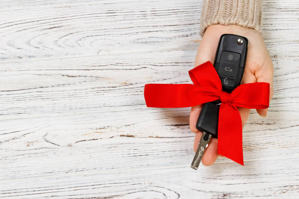 istock Car key with red bow on wooden background. Valentine's Day concept 891502184