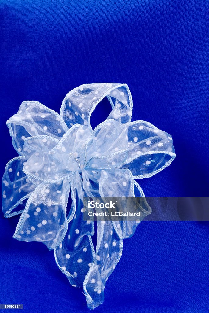 Bellissimo fiocco bianco con pois su sfondo blu - Foto stock royalty-free di Bianco