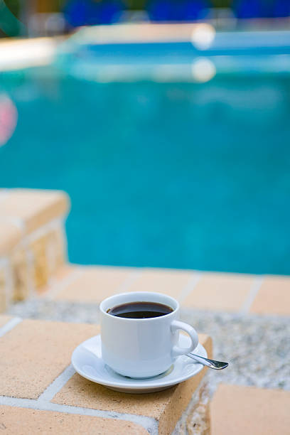user generated content of beach bar table on the seafront beach in front of a coastal village on the sea. coffee break on a summer vacation trip.