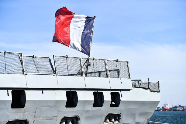 French frigate tied to a dock  in a harbor