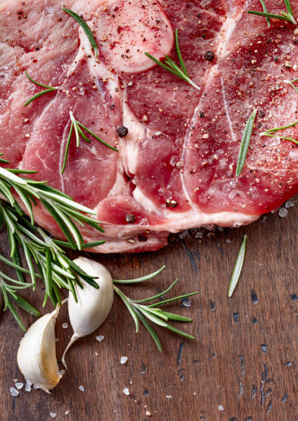 istock Raw pork with rosemary , salt and pepper. 891523178