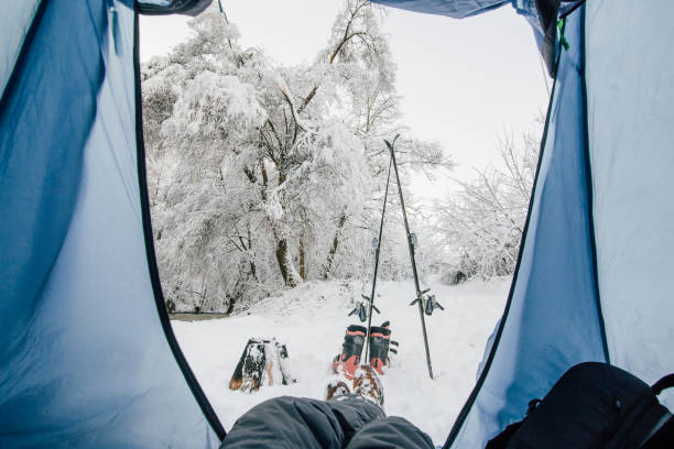 istock Man lying down in his tent in the winter forest 891526986