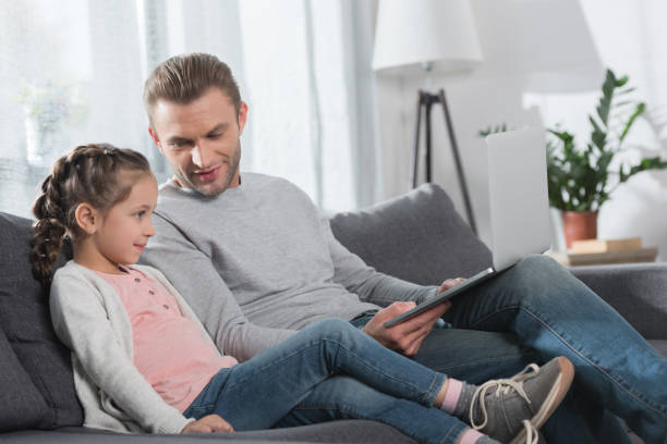 istock Father and daughter looking at laptop 891527740