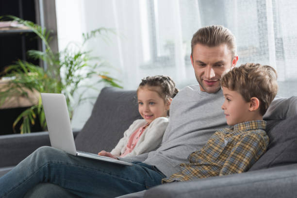 istock Father sitting with children on sofa 891531228