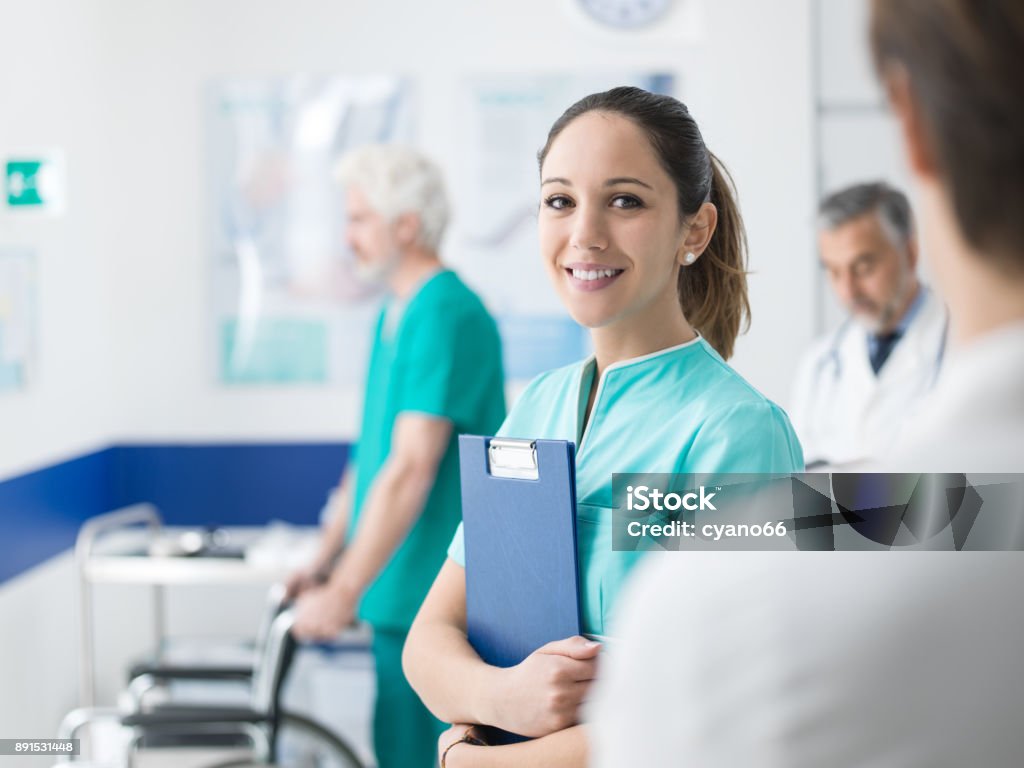 Young nurse working at the hospital Young female medical student working at the hospital and medical staff, she is holding medical records Nurse Stock Photo