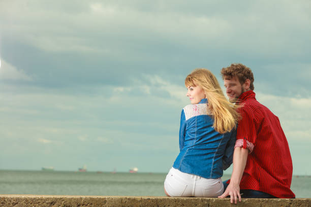 istock Couple sitting hugged on sea shore 891536588