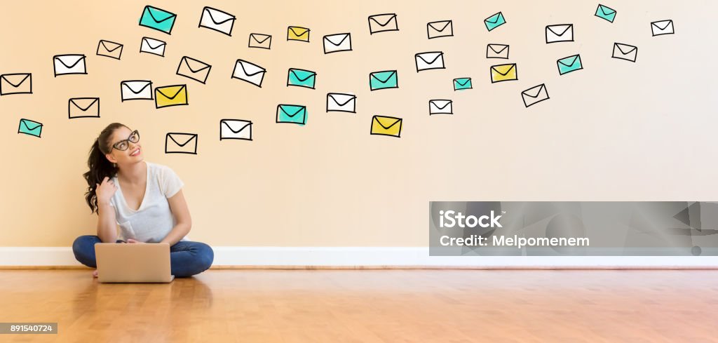 Email with young woman using a laptop computer Email with young woman using a laptop computer on floor E-Mail Stock Photo