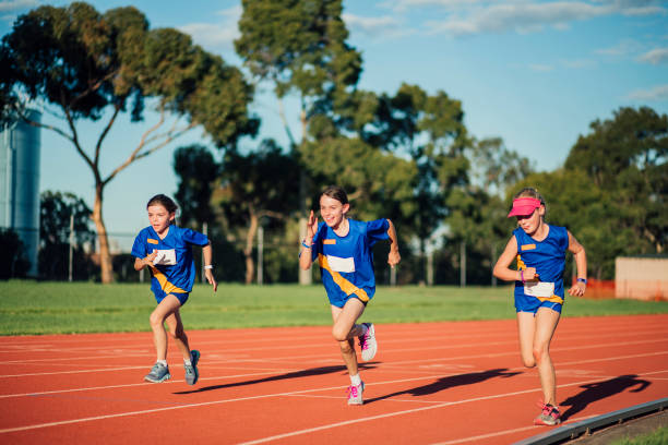 Racing At Athletics Club Three girls are racing on the running track in athletics club. sports training australia stock pictures, royalty-free photos & images