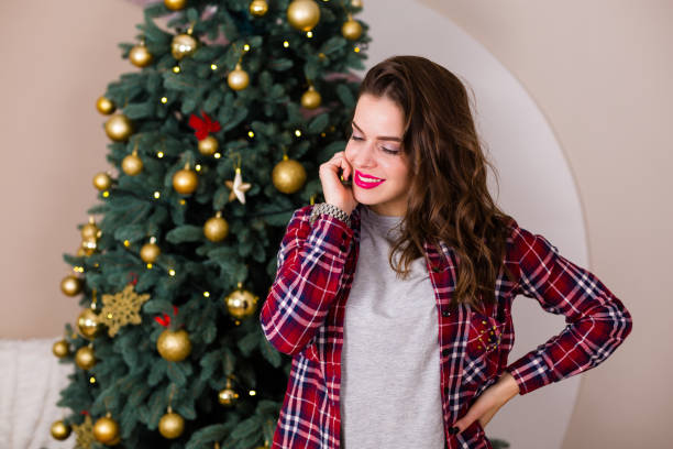 istock Woman standing near the Christmas tree 891552874