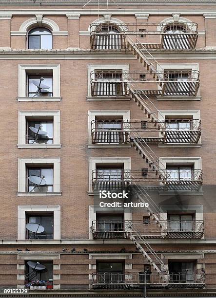 Brick Building With Fire Escape Stairs And Satellite Dishes Stock Photo - Download Image Now