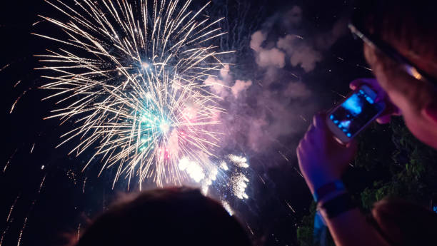 istock Woman photographing fireworks celebration 891559216