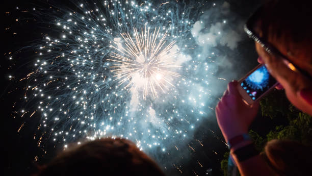 istock Woman photographing fireworks celebration 891559432