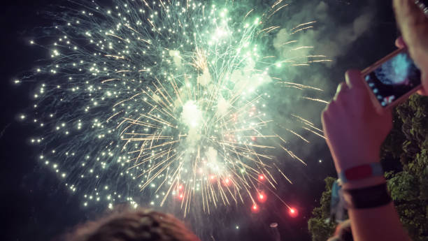 istock Woman photographing fireworks celebration 891559650